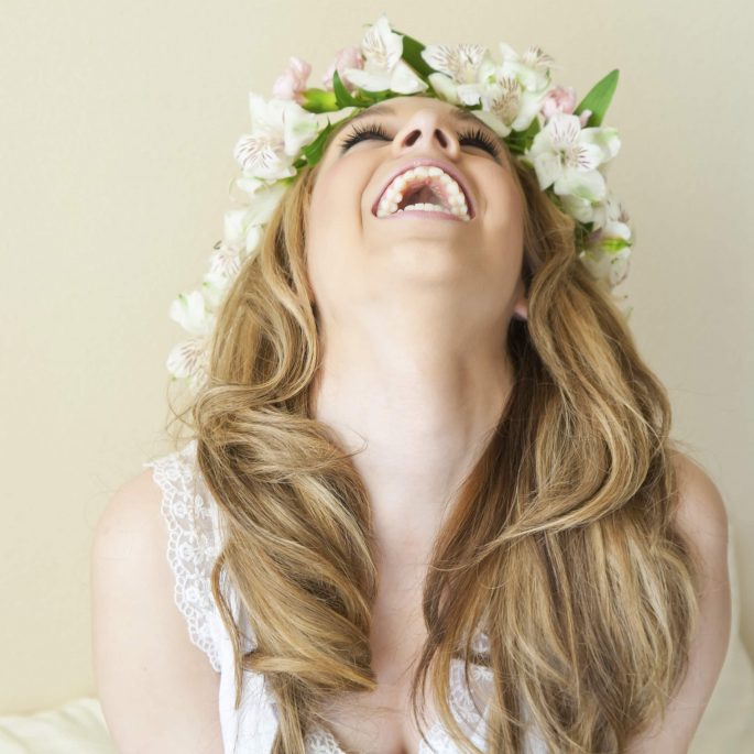 "young woman laughing, her head thrown back"